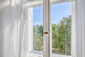 Enjoy a serene view of the lush garden from this window, offering a glimpse of the surrounding area.