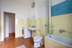 Bathroom features a bathtub, toilet, and washing machine.