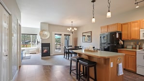 A spacious kitchen with a central island, wooden cabinets, and a built-in oven.