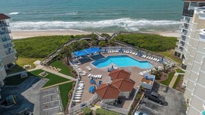 A resort with a pool, beach view, and multiple balconies. - ☀️Beachfront☀️ 2Br 2Ba with Heated Pool, Playground, Gym, and Arcade! (North Topsail Beach)