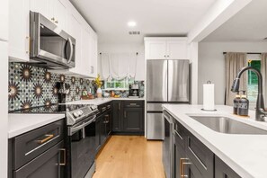 A modern kitchen with a microwave, stove, oven, and refrigerator.