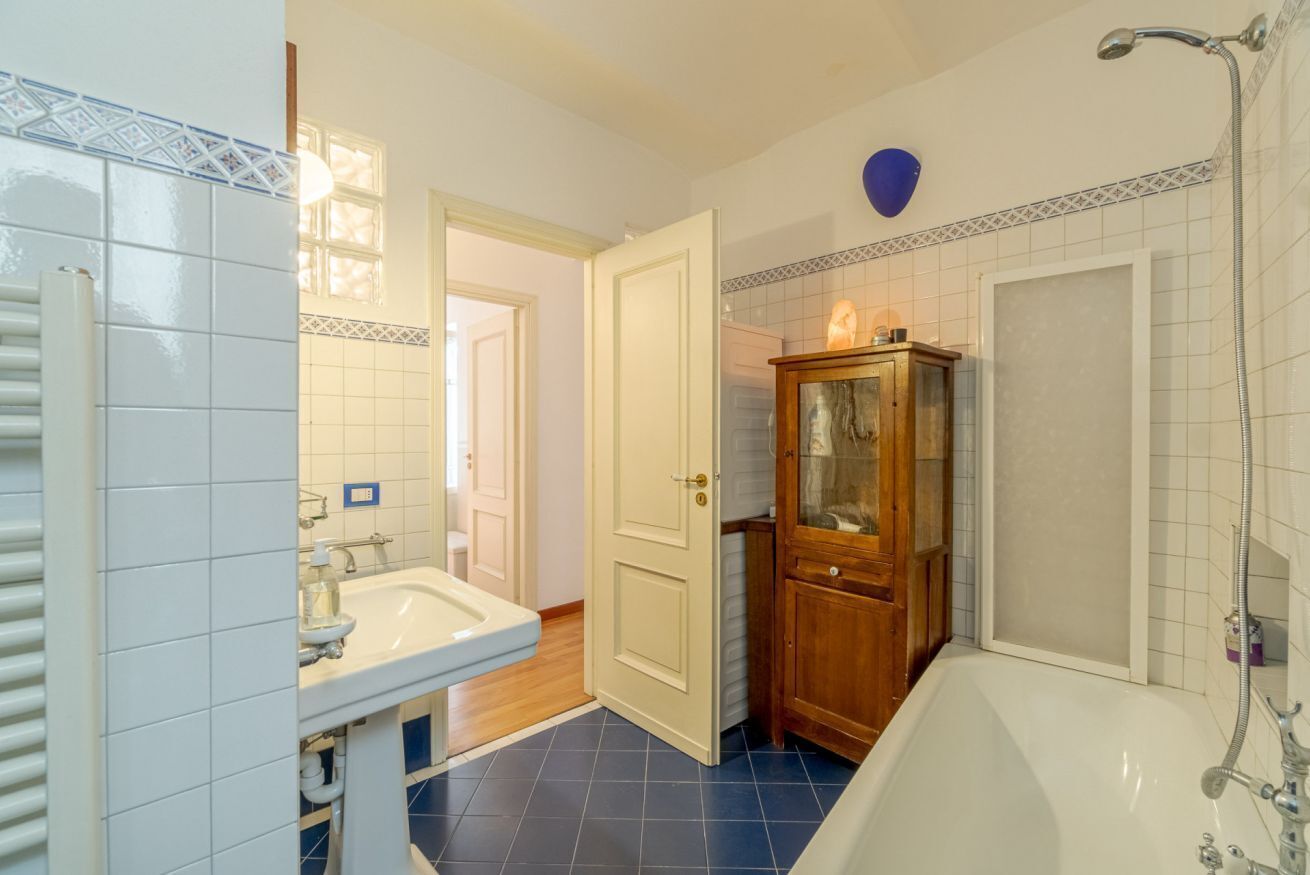 Un bagno con una vasca, un lavandino e un armadietto in legno.