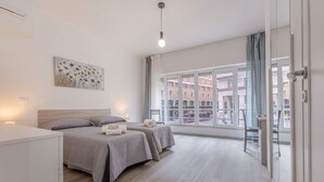 Ein modernes Hotelzimmer mit zwei Betten, einem großen Fenster und Blick auf die Stadt.