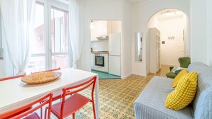 Un espace de vie compact comprenant un coin repas, une cuisine et un coin salon confortable.
