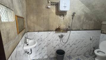 A bathroom with a sink, toilet, shower, and a water heater.