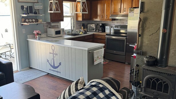 Una cocina con armarios de madera, una isla central, una estufa y un refrigerador.