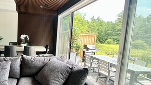 A modern interior with a large sliding glass door leading to an outdoor patio.
