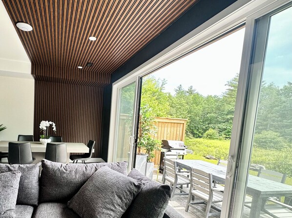 A modern interior with a large sliding glass door leading to an outdoor patio.