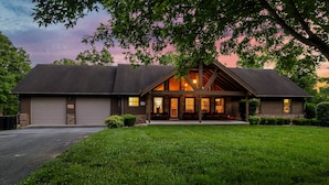 A two-story house with a garage, a covered front porch, and a well-maintained lawn. - 6BR-Epic Yard-Game And Movie Rooms (Sevierville)