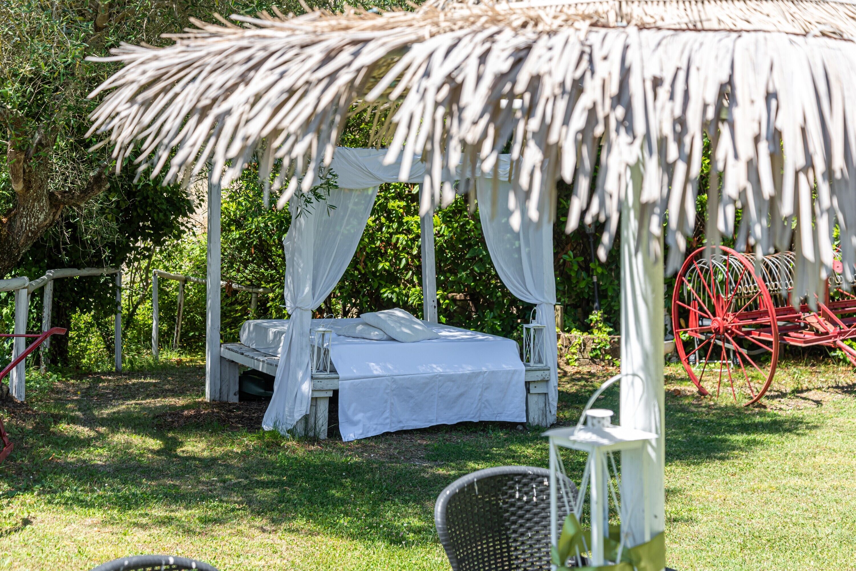 Ein Bett unter einem Baldachin in einem Garten.
