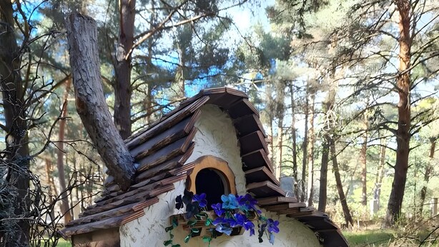 Una casa de madera rústica con dos puertas arqueadas y un pequeño porche.