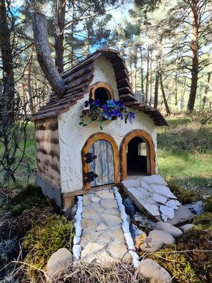 Een rustiek houten huis met twee gewelfde deuren en een klein portaal.