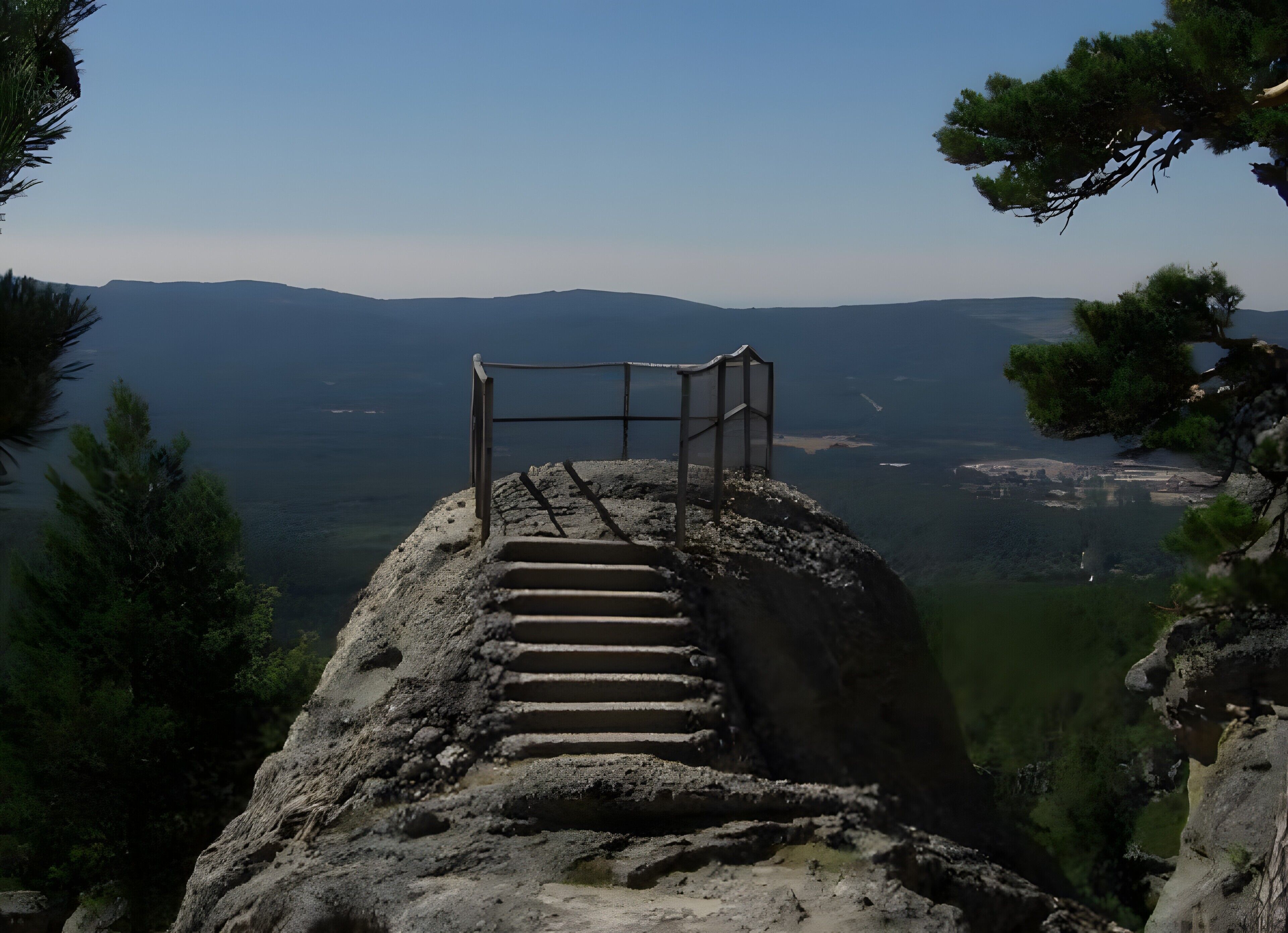 Un escalier menant à une plateforme d’observation dotée d’une rambarde en métal, entourée d’un paysage rocheux et de pins.