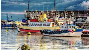 A harbor with boats docked, a building with a sign reading "Venture Seafood," and a cloudy sky. - 1 Bed Studio Sleeps 4 - Seaside, Dog Friendly (Bridlington)