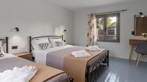 A bedroom with two beds, a desk, and a chair.