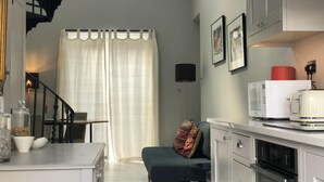 A modern kitchen with white cabinets, a microwave, and a toaster. There is a staircase with black railings leading to another level. - Wimbledon - Apartment - Sleeps 2 -Private Entrance (London)