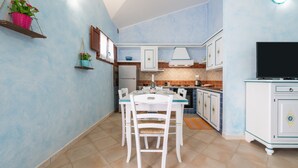 Une cuisine de taille réduite comprenant une table à manger, des chaises et un téléviseur.