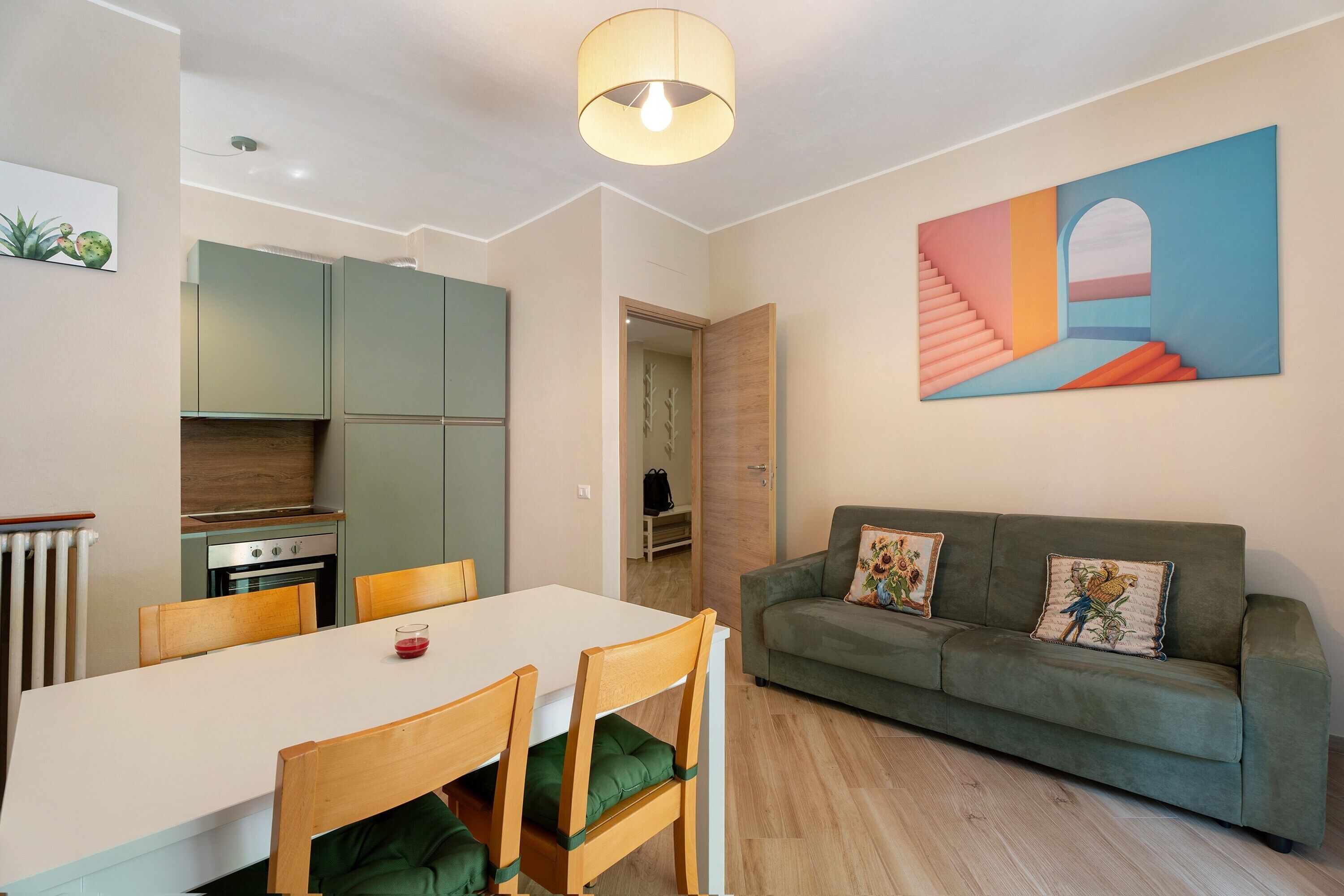 Une cuisine moderne avec un coin repas, un canapé et un tableau au mur.