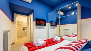 A hotel room with a bed, a TV, and a bathroom.