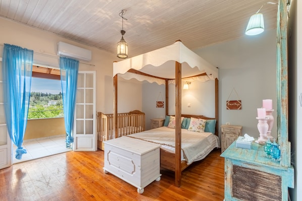 A four-poster bed with a wooden frame, a white bedside table, and a nightstand with a lamp.