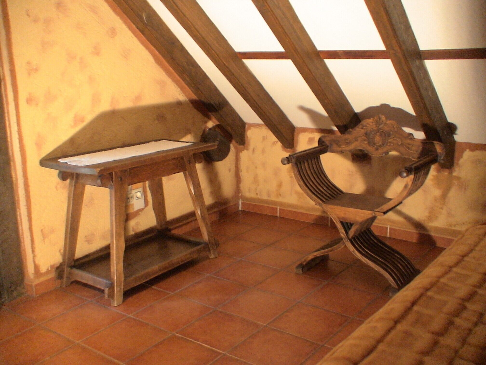 A room with a wooden bench, a small table, and a tiled floor.