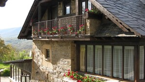 A stone building with a balcony, large windows, and a stone staircase. - Country House 'Cuarto Del Ama' with Mountain Views, Private Garden and Wi-Fi (Rozas De Sanabria)