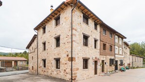 Un bâtiment en pierre doté de nombreuses fenêtres et d’un toit plat.