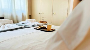 A neatly made bed with a tray of food and drinks, a towel, and a wooden tray. - Sea Breeze Sanctuary-1bd 3pl 1ba - 90m To Sea (Chania)