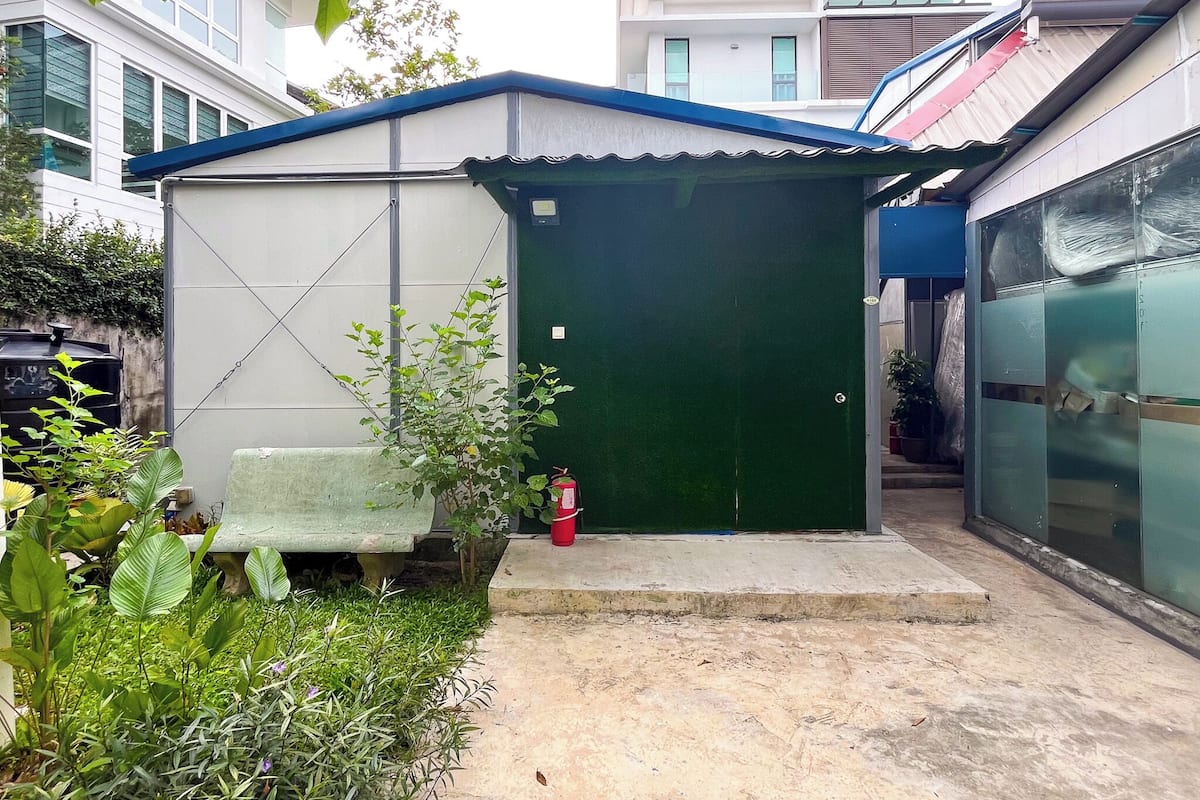 A small, single-story building with a green door and a white exterior.