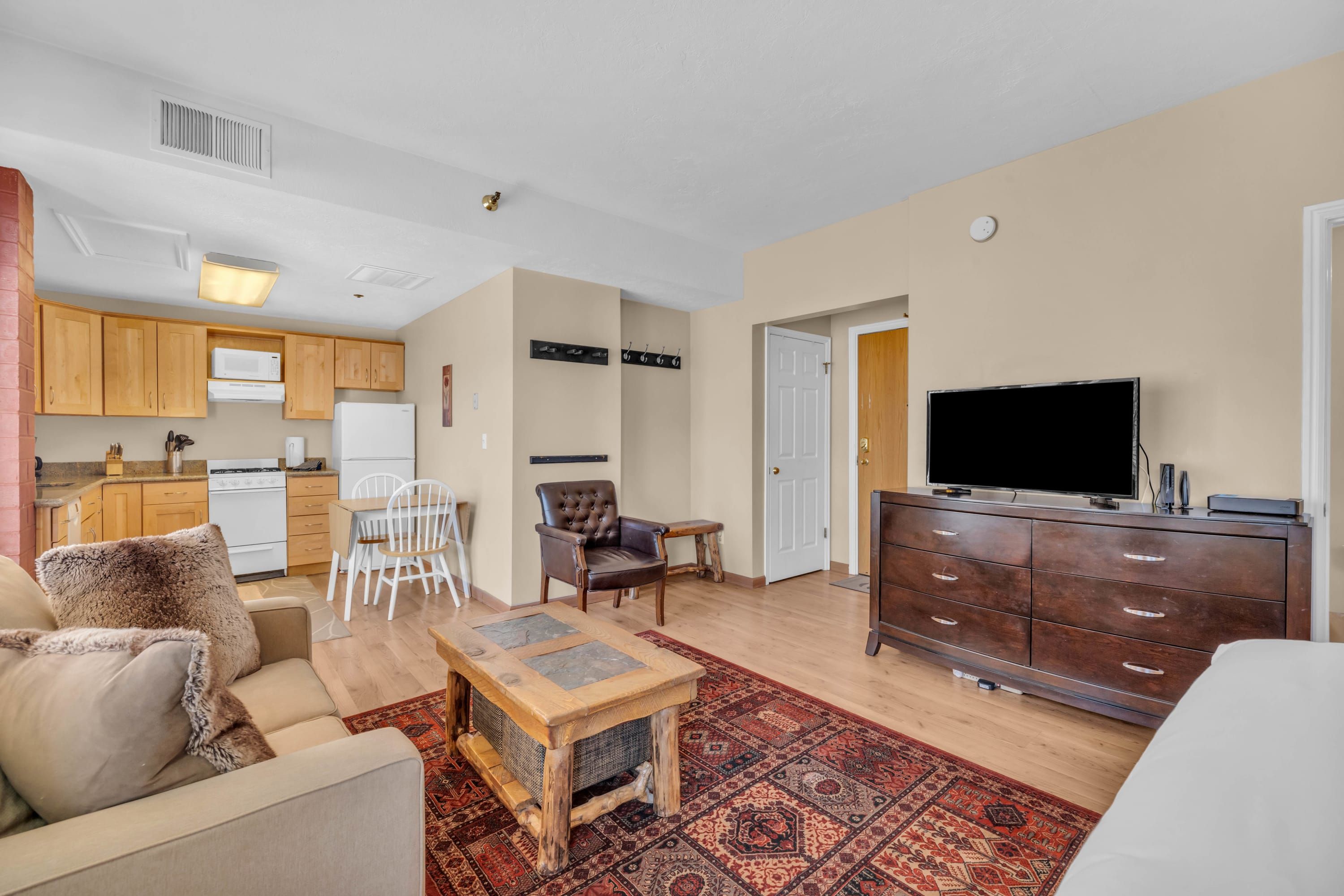 Un apartamento moderno con sala de estar, comedor, cocina y televisor en la zona de entretenimiento.