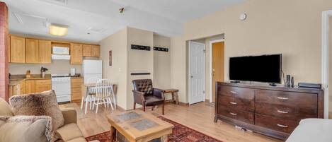 Un apartamento moderno con sala de estar, comedor, cocina y televisor en la zona de entretenimiento.