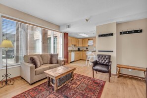 A living room with a sofa, a coffee table, and a patterned rug. - Charming Studio in the Heart of Park City! (Park City)