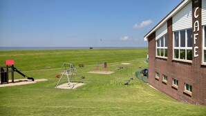 Een gebouw met de aanduiding 'CAFE' en een speeltuin op de voorgrond.