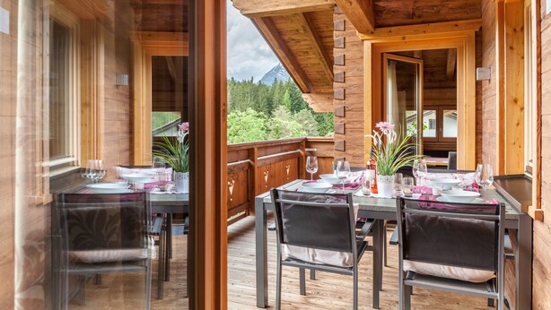 A wooden deck with a table set for dining, overlooking a mountainous landscape. - 'Blockhaus Sonnenspitz' holiday flat with mountain views, communal garden and WLAN (Leutasch)