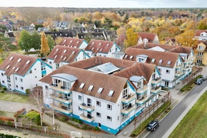 A residential building with multiple floors, balconies, and a visible sign indicating it is a residence.