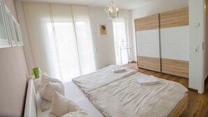 Une chambre à coucher avec un grand lit, un luminaire suspendu et une armoire aux portes coulissantes.