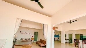 A spacious living area with a bed, sofa, and dining area. - Jeju Beach Front Villa (Da Nang)