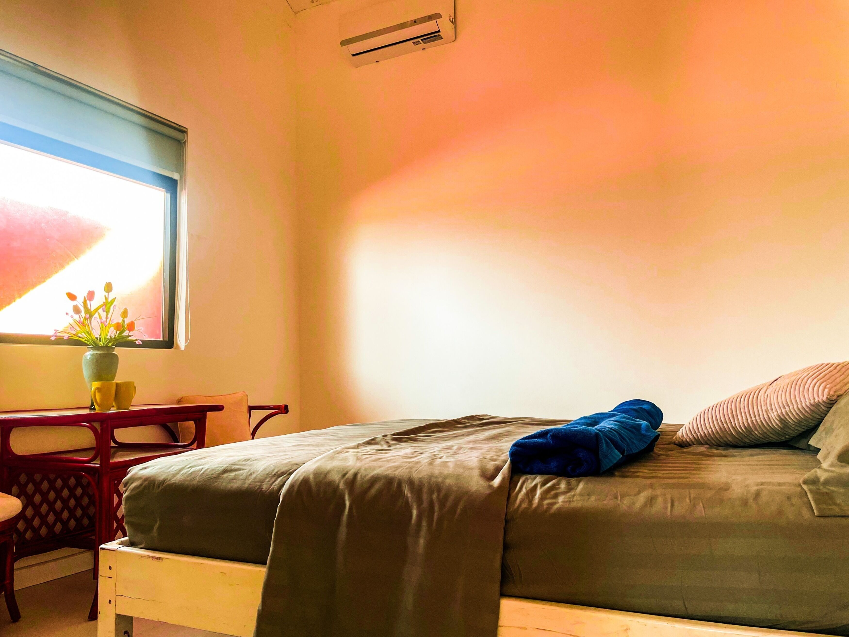 Un dormitorio con cama, ventana con vistas, escritorio y una silla.