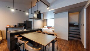 Una cocina moderna con una isla central, taburetes de bar y una mesa de comedor.