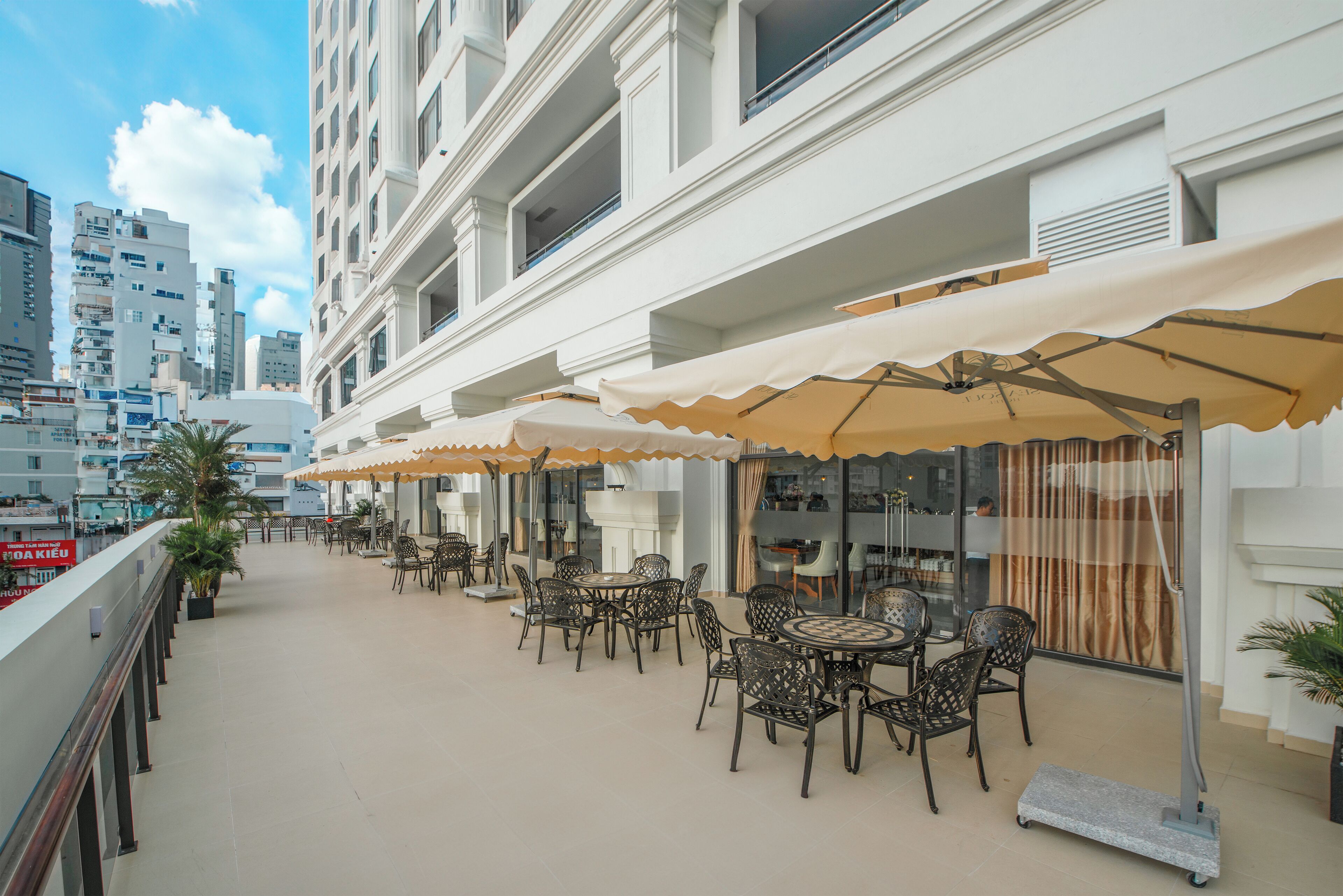 A rooftop terrace with outdoor seating, a view of the cityscape, and a modern building facade.