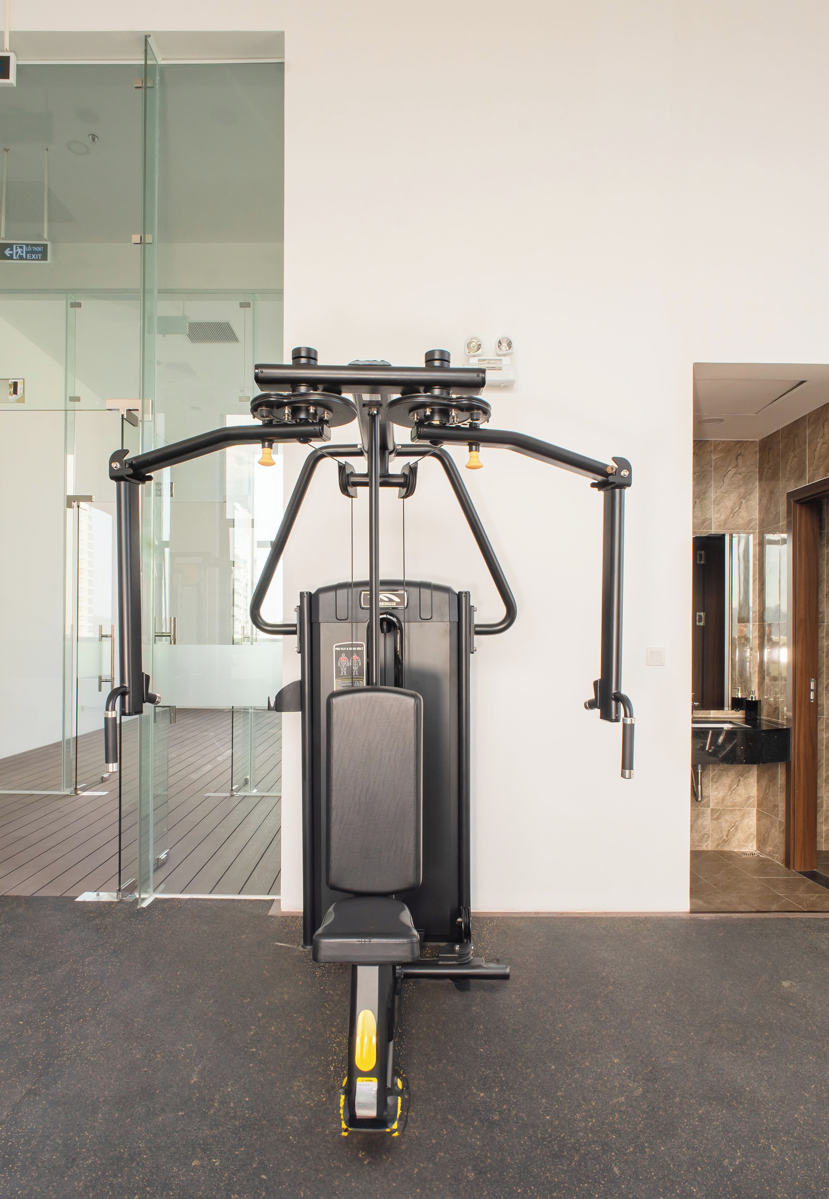 Un gimnasio con una bicicleta estática, una barra de dominadas y una máquina de ejercicios fijada a la pared.