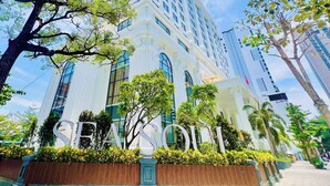 A tall, modern hotel with a prominent entrance, large windows, and a well-maintained garden area. - Sea Soul Hotel (Nha Trang)