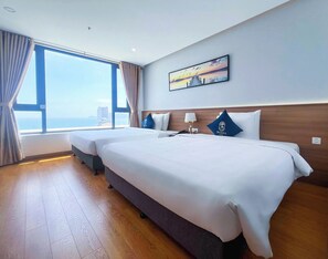 Habitación familiar con 2 camas individuales, vista al mar | Minibar, caja de seguridad en la habitación y escritorio 
