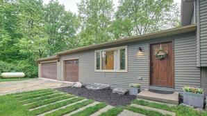 A residential house with a garage, a front porch with a welcome mat, and a well-maintained lawn with a stone pathway. - Spacious Riverfront Delaware Home w/ Views (Delaware)
