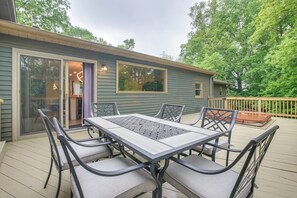 A deck with a table and chairs, a sliding glass door, and a small deck area with a railing. - Spacious Riverfront Delaware Home w/ Views (Delaware)