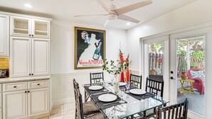 A dining area with a glass table, black chairs, and a ceiling fan. - Hobe Sound Villa w/ Screened Porch: 4 Mi to Beach (Hobe Sound)