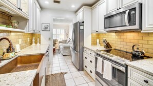 A modern kitchen with white cabinets, stainless steel appliances, and a tiled backsplash. - Hobe Sound Villa w/ Screened Porch: 4 Mi to Beach (Hobe Sound)