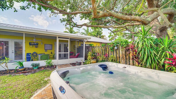 A house with a hot tub in the backyard, surrounded by lush greenery and a large tree. - Hobe Sound Villa w/ Screened Porch: 4 Mi to Beach (Hobe Sound)