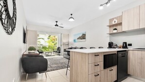 Una cocina moderna con una isla central, armarios de madera y lavavajillas.