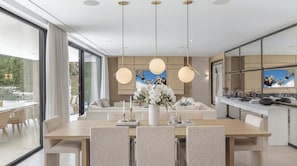 Un comedor moderno con una mesa grande, sillas e iluminación colgante.